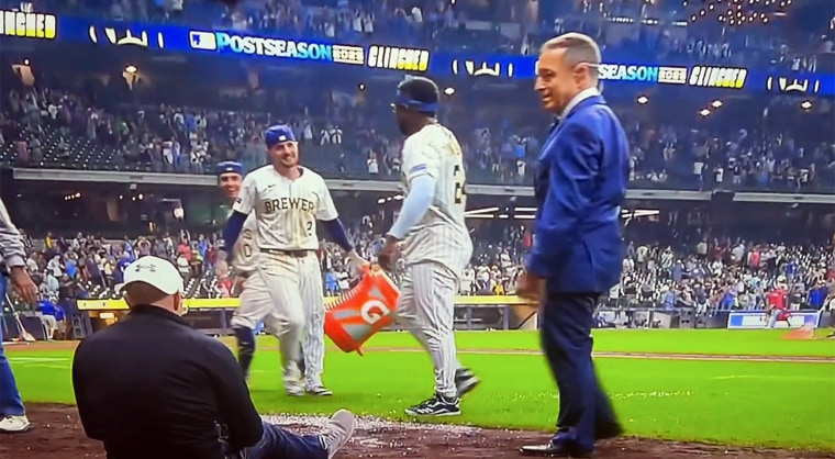 Ken Rosenthal (right) looks at Scott Paulus (seated, left) after dodging the Brewers' Gatorade bath.  