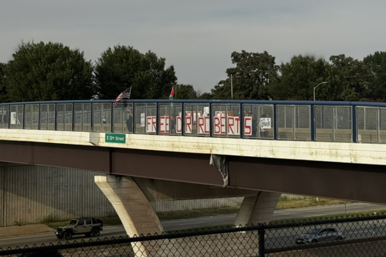 A banner over the interstate that cuts across the center of the city reading “Free Dr. Roberts,” in Des Moines.