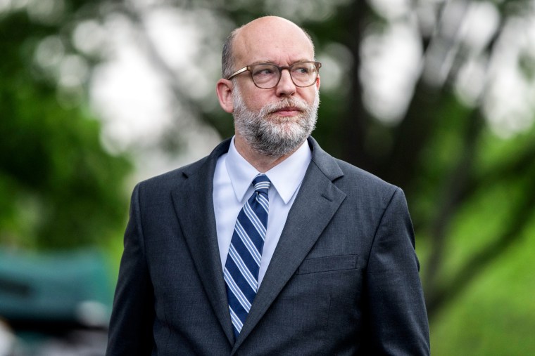 Russell Vought stands outside