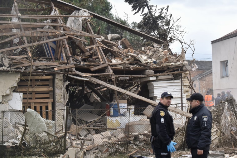 Agentes de la policía ucraniana se encuentran junto a un edificio destruido en el lugar de un ataque aéreo en Lapaivka, región de Lviv, el 5 de octubre de 2025, en medio de la invasión rusa de Ucrania.