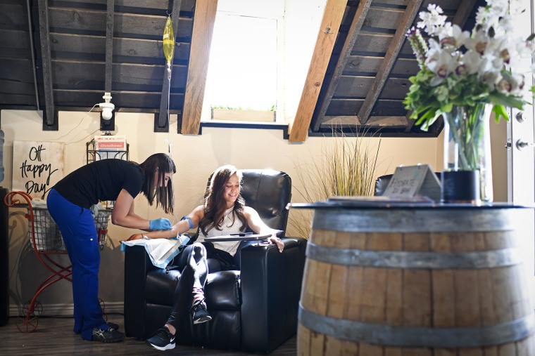 A nurse prepares a patient for an IV at Hydrate IV Bar