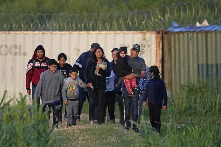 Migrants walk past a barrier after they crossed the Rio Grande and entered the U.S. on Oct. 19, 2023, in Eagle Pass, Texas. 