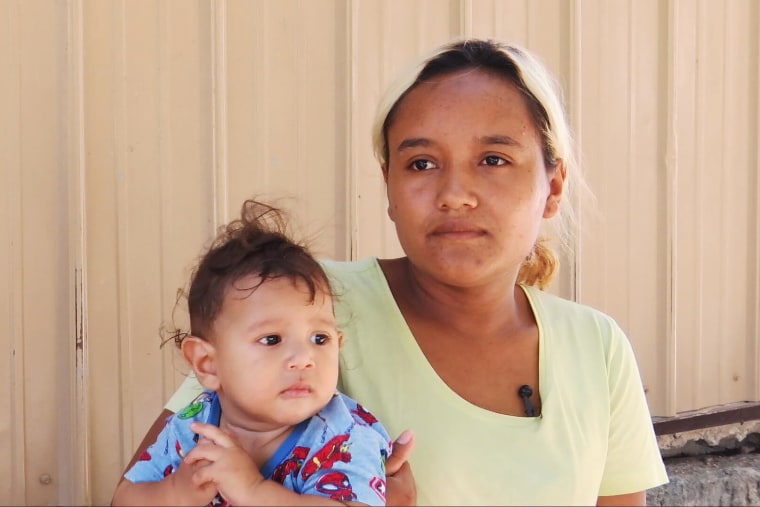 Johana Romero, a migrant woman from Honduras, holds her six-month old baby inside a migrant shelter in Mexico. 