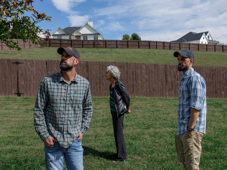John Middleton walks with James Middleton and Linda Middleton outside in a backyard