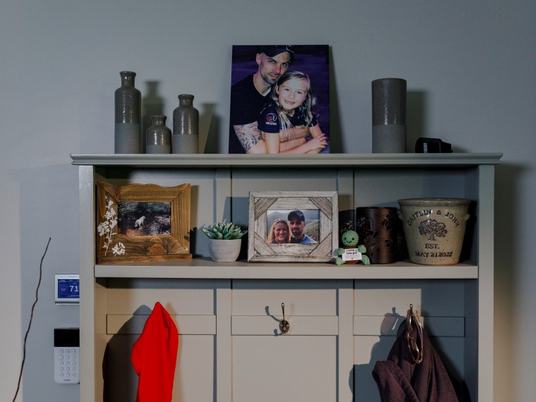 A framed photo display featuring John Middleton and his family sits atop a mantle