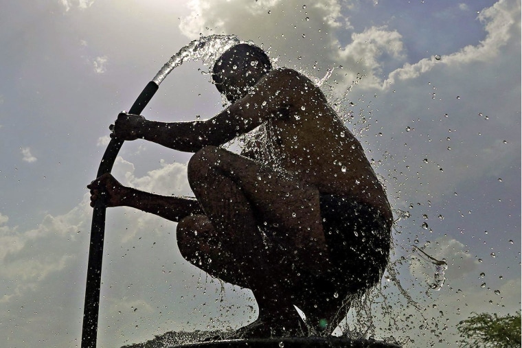 A man cools off with a hose during a heatwave in Ajmer, India, in June 2024.