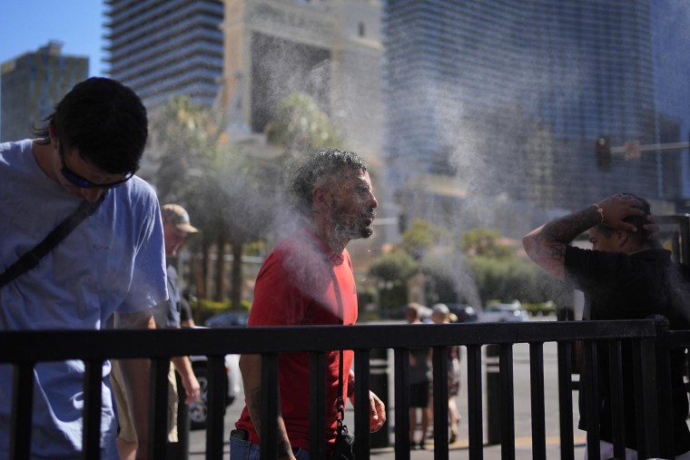 People cool off in misters along the Las Vegas Strip on July 7, 2024.
