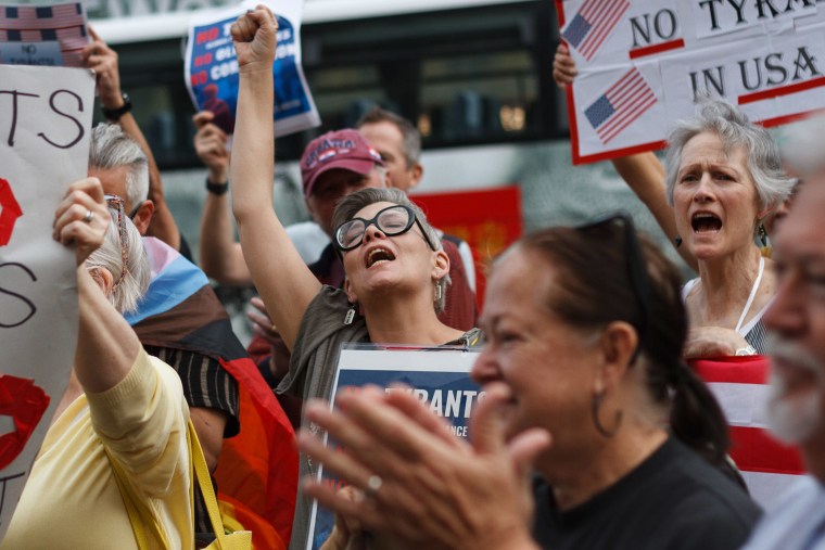 People hold signs and chant during the "No Tyrants" protest
