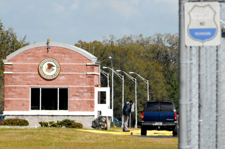A security guard speaks to the driver of a vehicle entering