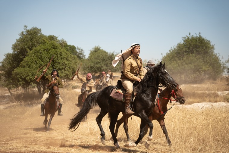 People ride on horses outside during the day