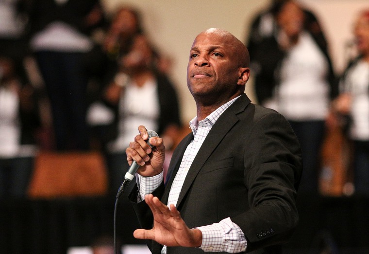 Donnie McClurkin on stage, holding a microphone