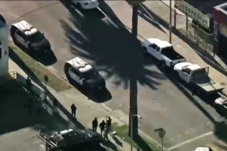 Police vehicles near the scene in South Los Angeles where a U.S. Marshal was among two people injured in a shooting.