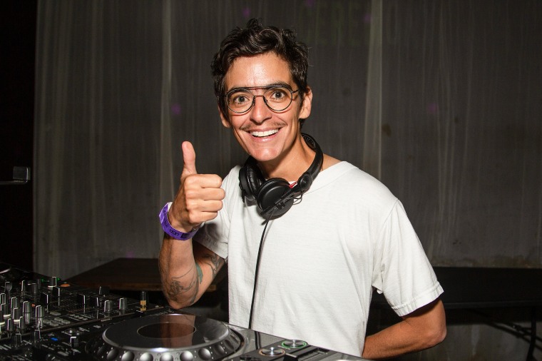 JD Samson smiles and gives the thumbs up while DJ'ing.