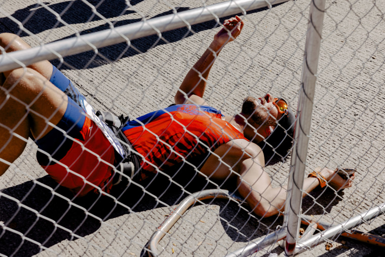 A Chicago Marathon runner falls to the ground after completing the race.