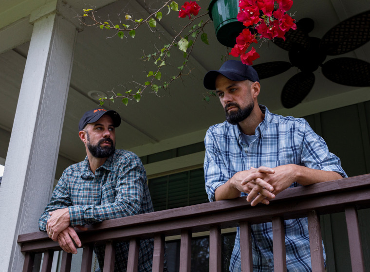 James Middleton, left, and John Middleton lean over the railing of a porch