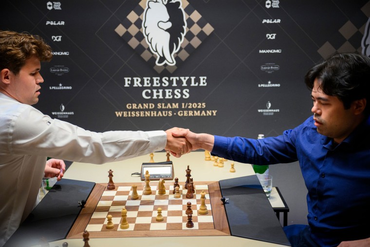 Magnus Carlsen, kiri, dan Hikaru Nakamura berjabat tangan di papan catur pada Grand Slam Catur Gaya Bebas di Jerman pada 7 Februari 2025.
