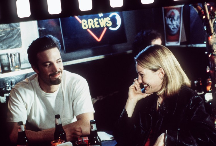 Ben Affleck and Joey Lauren Adams sitting at a table in a scene from the film 'Chasing Amy', 1997.