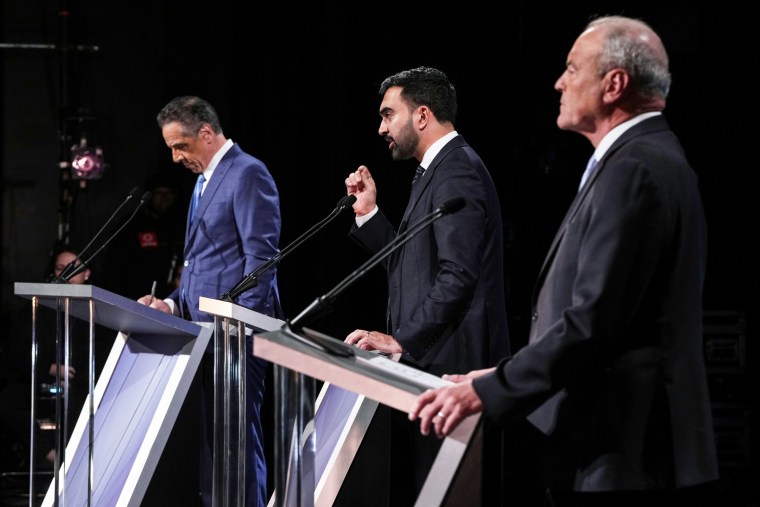 Andrew Cuomo, left, Zohran Mamdani, and Curtis Sliwa on stage, standing behind podiums