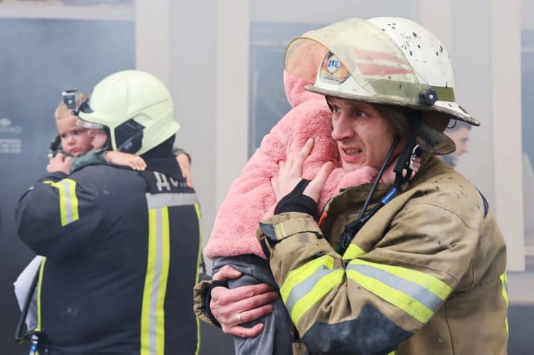 Firefighters evacuate children following a Russian drone strike on a kindergarten