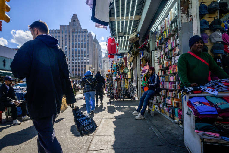 people walk on the street past vendors