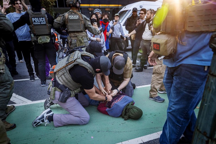 A protester is arrested as law enforcement conduct a raid on street vendors during rush hour on Oct. 21, 2025 in New York.