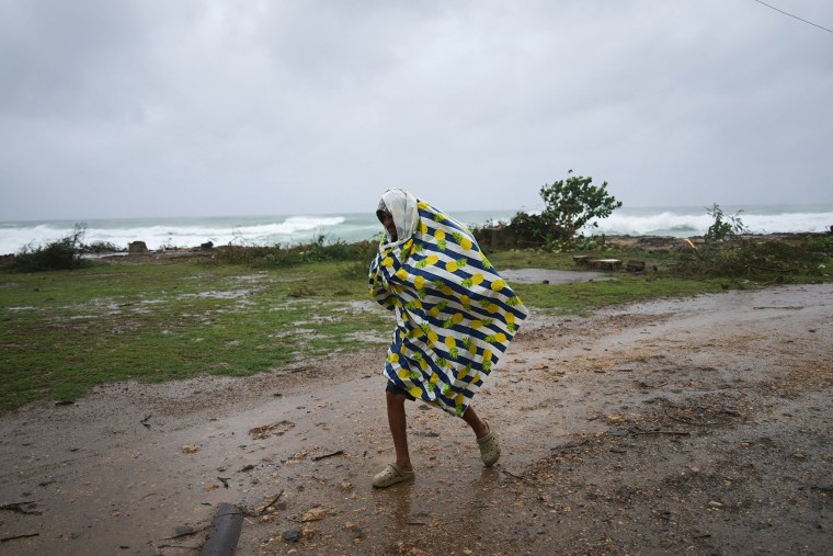 A man walks in the rain before the arrival of Hurricane Melissa in Santiago de Cuba, Tuesday, Oct. 28, 2025.