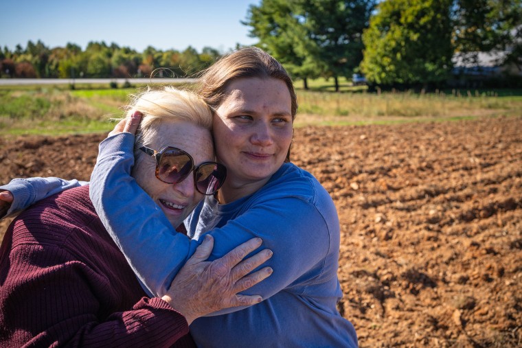 Farmer Rebecca Stoecker-Dolly embraces her mother, Weida Stoecker, as they discuss the impact of proposed power lines in Parkland, Md.