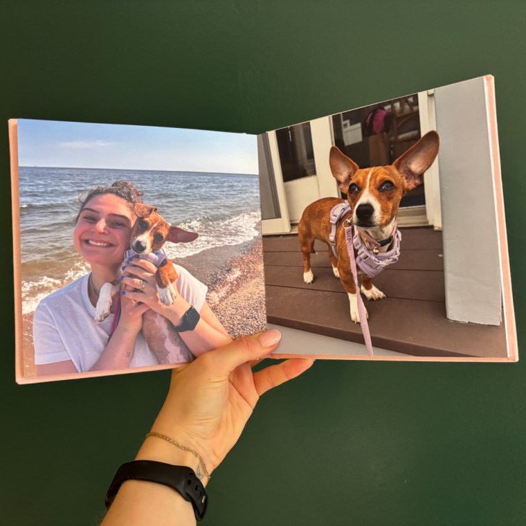 Woman holding open a photo book with pictures of her and a dog