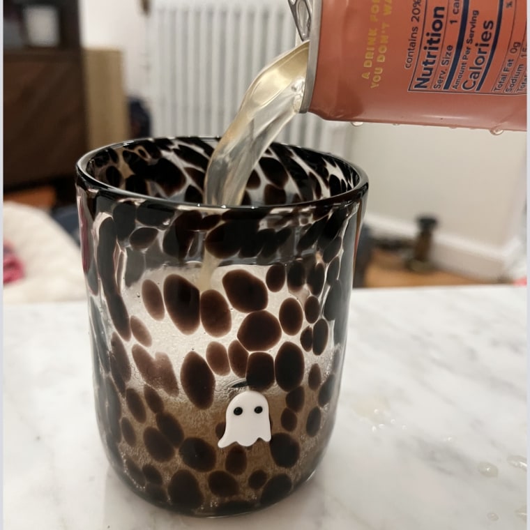 A hand pouring Recess’ Paloma into a glass cup.