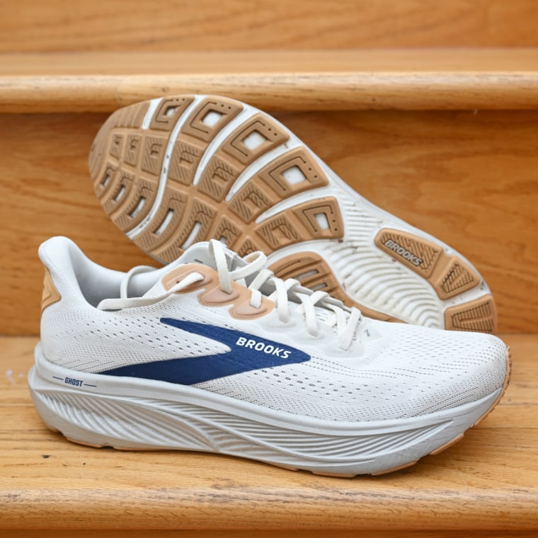 A close up of the Brooks Ghost 17 in white, resting against a wooden stair.
