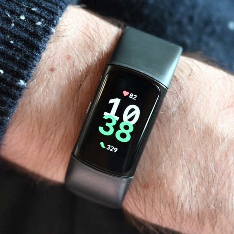 A close-up of the FitBit Charge 6, showing the time on the wrist of the writer.