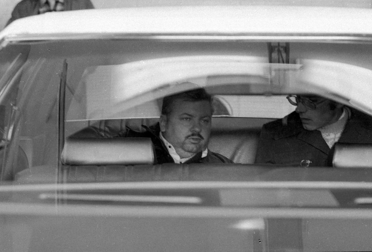 John Wayne Gacy saindo da Delegacia de Polícia de Des Plaines em 23 de dezembro de 1978. 