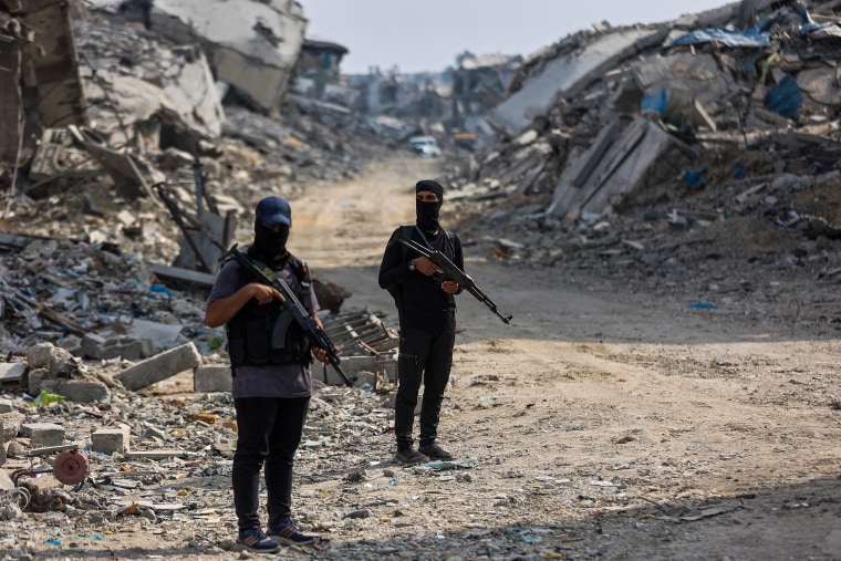 Hamas militants guard an area where they are searching for the bodies of hostages with the help of the International Committee of the Red Cross.