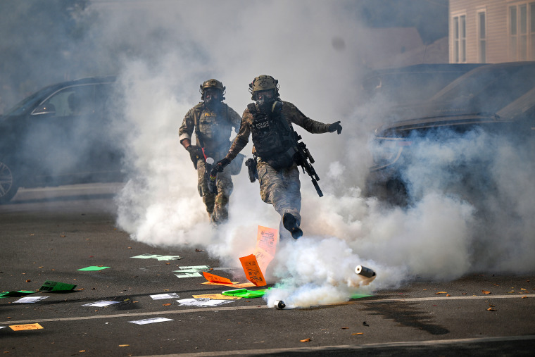 ICE Agents kicking a canister of tear gas towards protestors (not in frame).