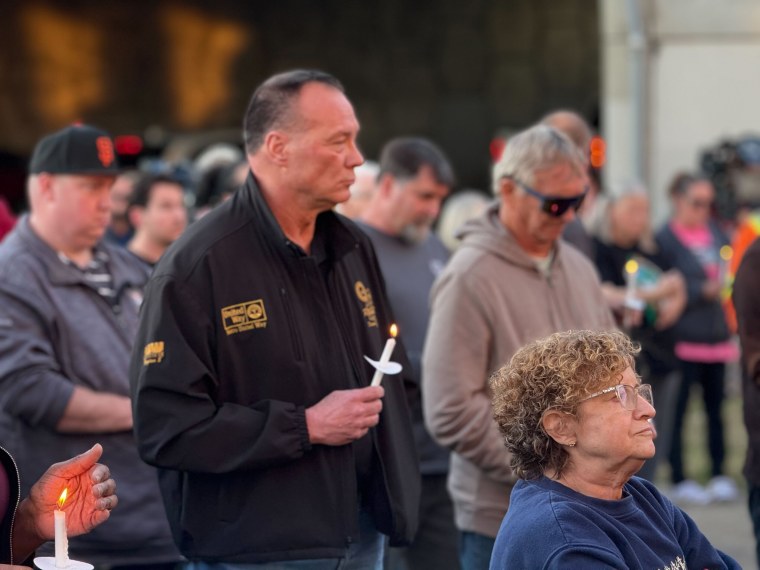 People gather outside the Teamsters Local 89 on Thursday for a vigil for the victims of a UPS plane crash this week in Louisville, Kentucky.