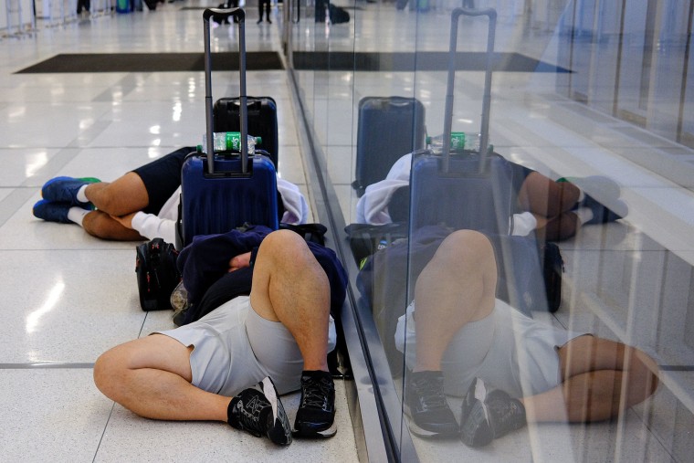Travelers sleep on the ground at LaGuardia airport in New York on Nov. 10, 2025. 