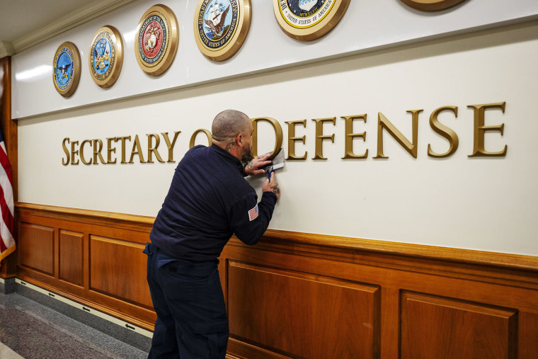 A worker changes the lettering to "Secretary of War" at the Secretary's corridor at the Pentagon on Sept. 3, 2025.