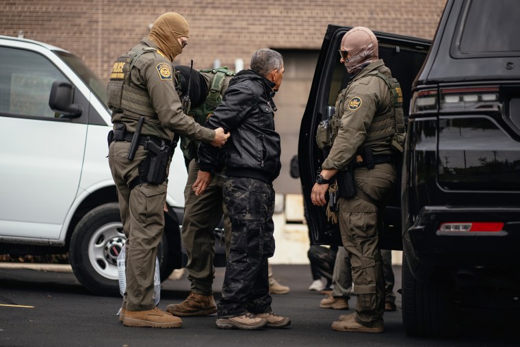 Immigration and Customs Enforcement agents take people they detained earlier to a parking lot before transferring them to an ICE facility in Chicago.