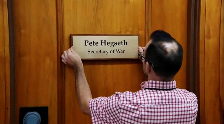 A worker places a plaque that reads "Pete Hegseth - Secretary of War" in Washington on Sept. 5, 2025.  