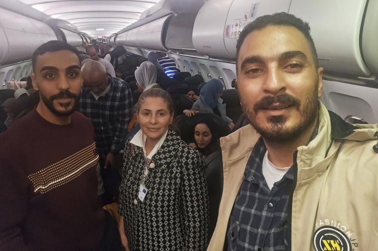 Hanan Jarrar, tengah, duta besar Palestina untuk Afrika Selatan, tersenyum saat berfoto di pesawat di Johannesburg, Afrika Selatan.