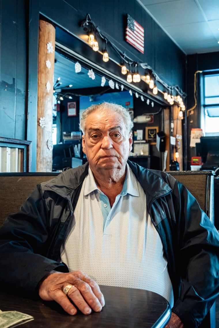 Sam Johnson sits at a booth inside of a cafe