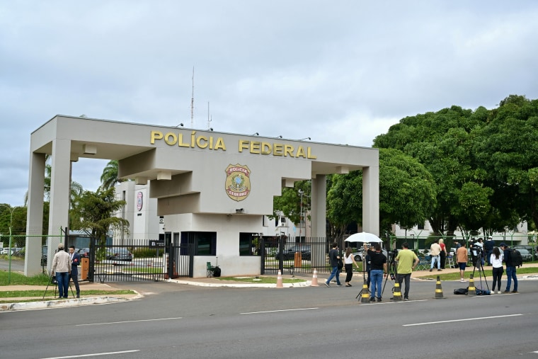 Journalists stand outside the Brazilian Federal Police Headquarters in Brasilia on Nov. 22