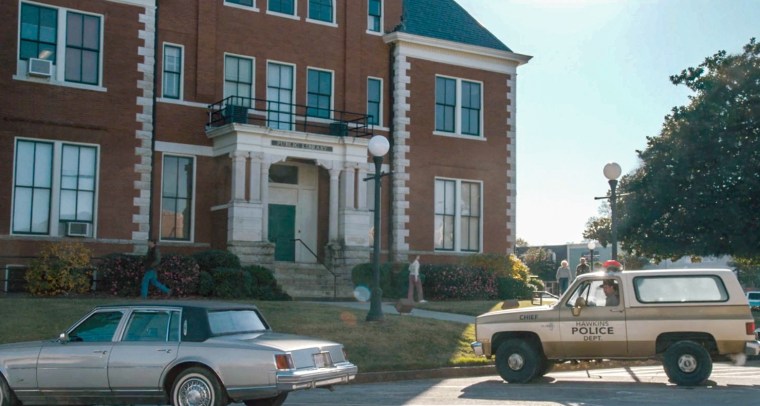 The exterior of Hawkins Library with cars parked out front