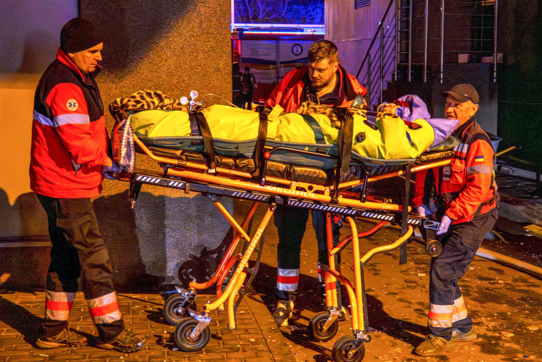 Rescue workers carry a person in a stretcher outside