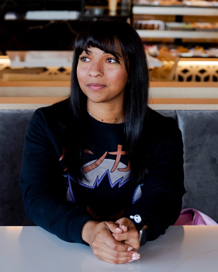 Jamie Fraser sits at a table inside a cafe