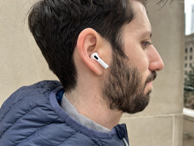 The writer wearing Apple AirPods 4 staring off to the side.
