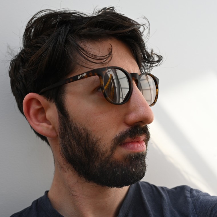 A closeup of a man wearing the Goodr Circle G Nine Dollar Pour Over sunglasses.