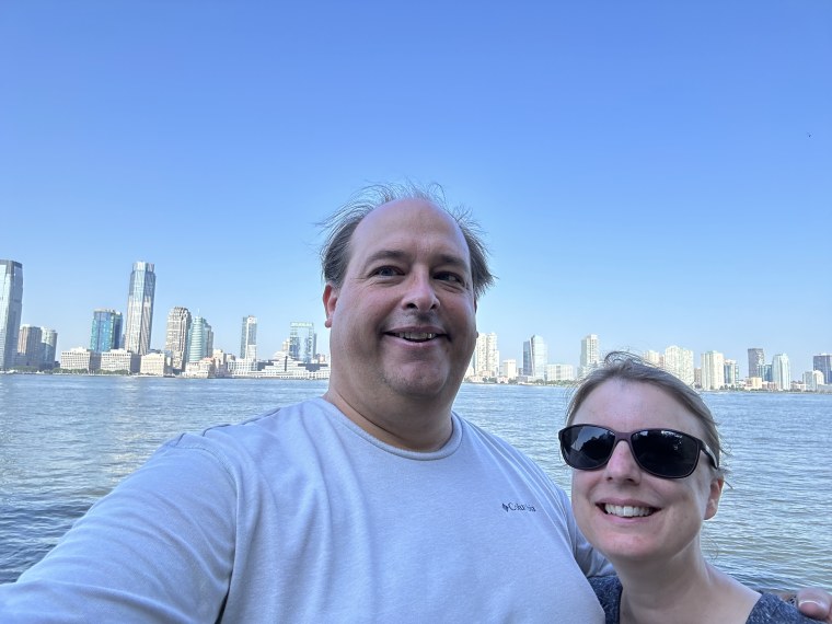 Men standing in new york city with his wife.