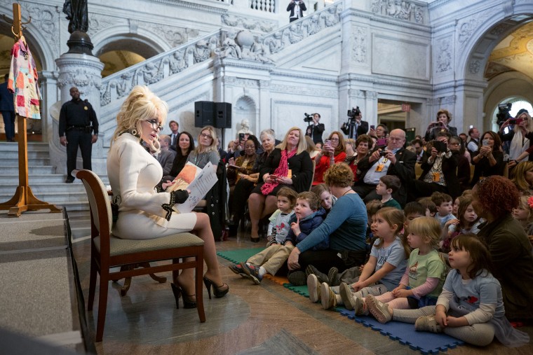 Dolly Parton reading a book to children.