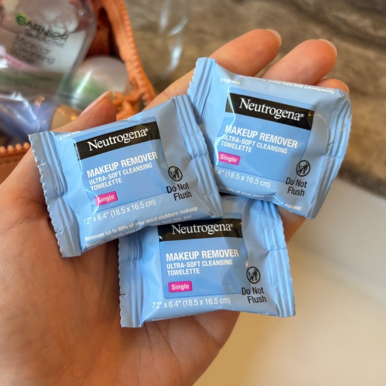Three Neutrogena Makeup Remove Wipes Singles in the palm of a person’s hand.